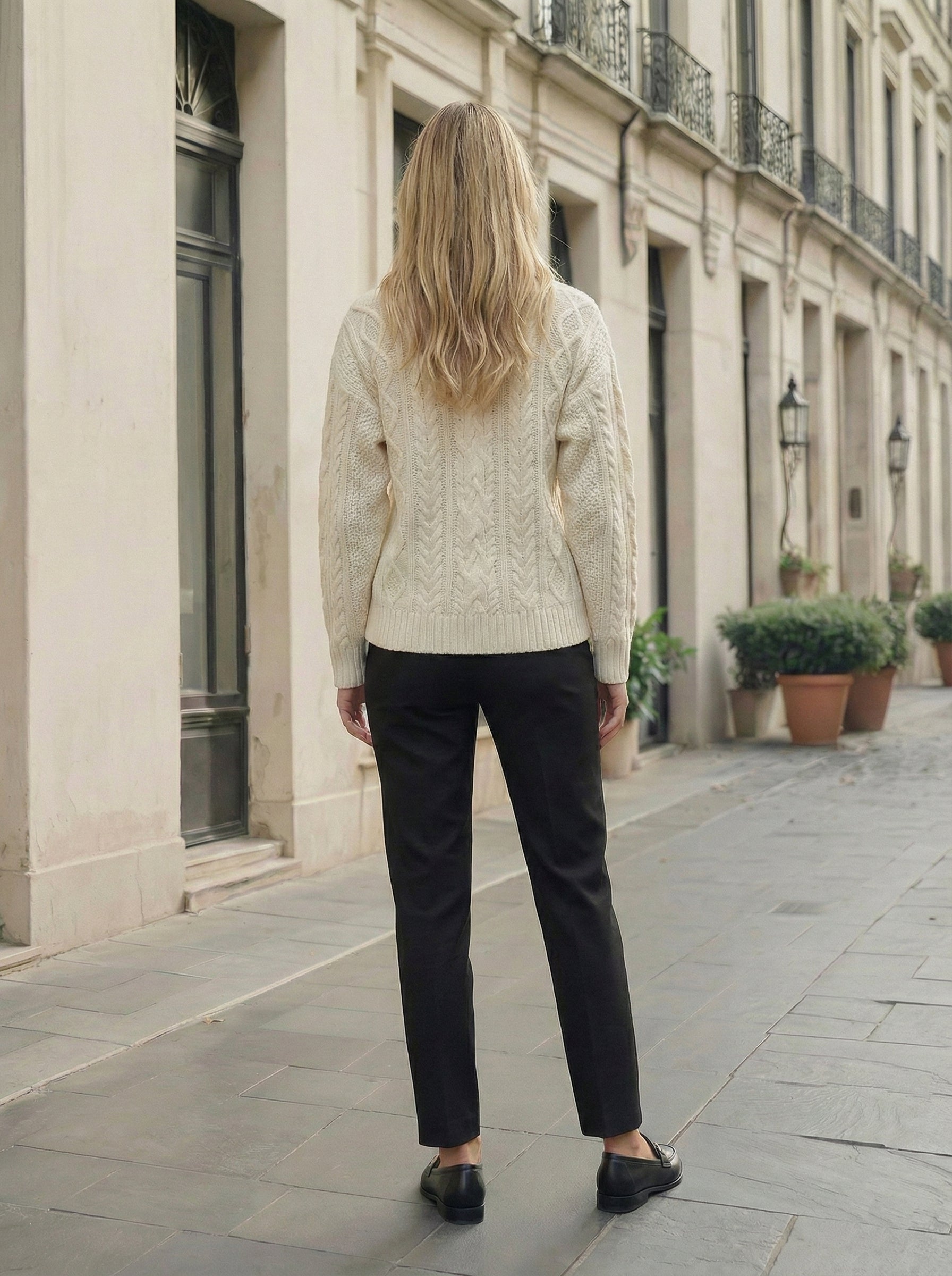 Back view of the ivory cashmere cable-knit pullover, showing the cable panels across the shoulders